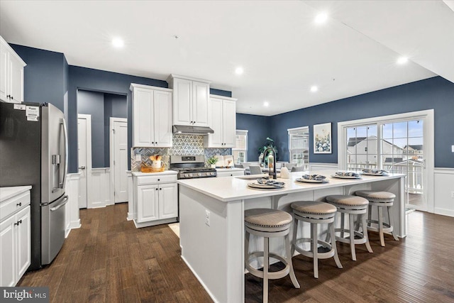 kitchen featuring appliances with stainless steel finishes, sink, white cabinetry, and a center island with sink