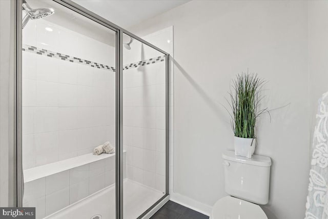 bathroom with a shower with shower door and toilet