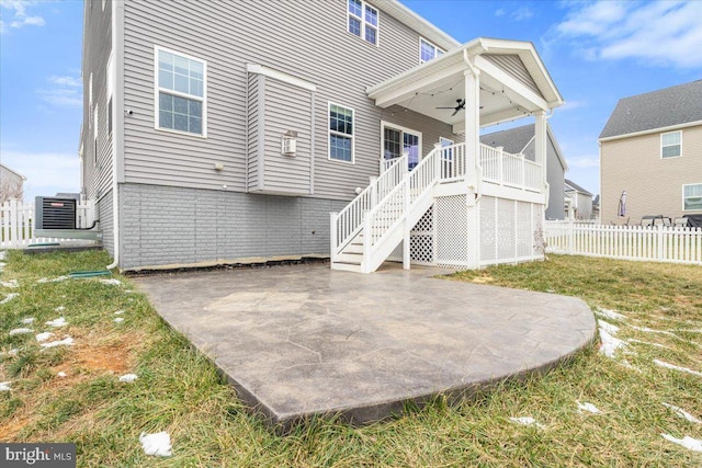 rear view of house with central AC unit, ceiling fan, a patio area, and a lawn