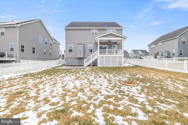 snow covered back of property with ceiling fan