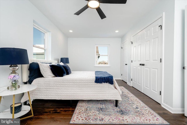 bedroom with multiple windows, ceiling fan, and dark hardwood / wood-style flooring