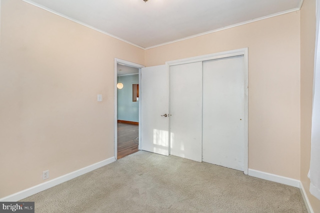 unfurnished bedroom with light colored carpet, a closet, and ornamental molding