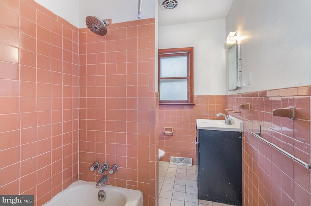 full bathroom featuring vanity, tiled shower / bath combo, tile walls, tile patterned flooring, and toilet