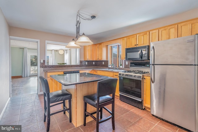 kitchen with a center island, light brown cabinets, stainless steel appliances, a kitchen breakfast bar, and decorative light fixtures