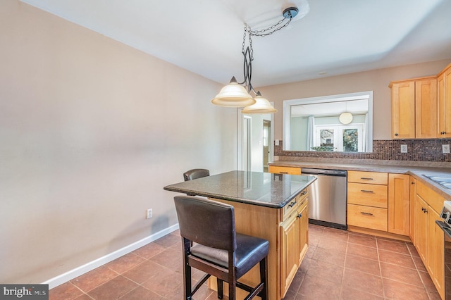 kitchen featuring light brown cabinetry, a kitchen breakfast bar, tile patterned floors, stainless steel dishwasher, and a center island