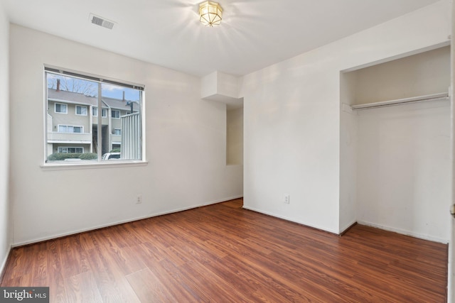 unfurnished bedroom with dark hardwood / wood-style floors and a closet