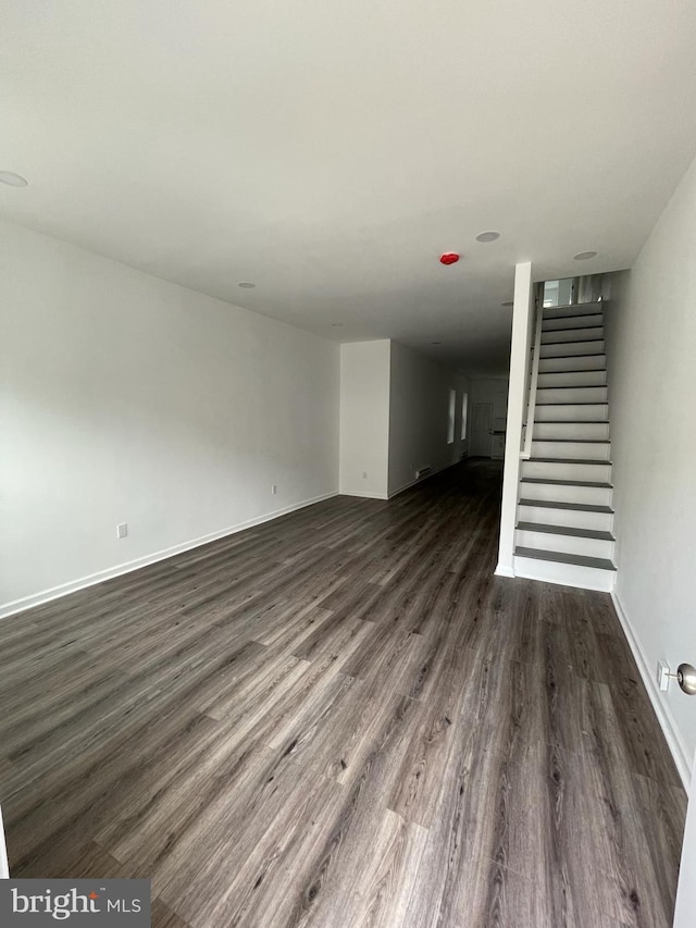 unfurnished living room with dark wood-type flooring