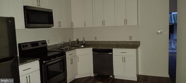 kitchen featuring dark hardwood / wood-style flooring, stainless steel appliances, sink, dark stone countertops, and white cabinets