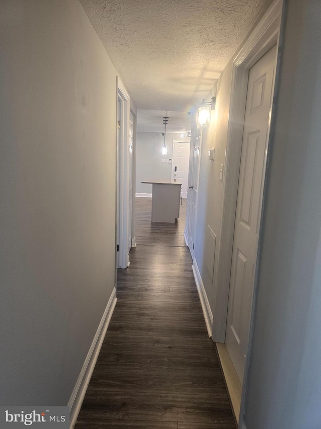 hall featuring dark hardwood / wood-style flooring and a textured ceiling