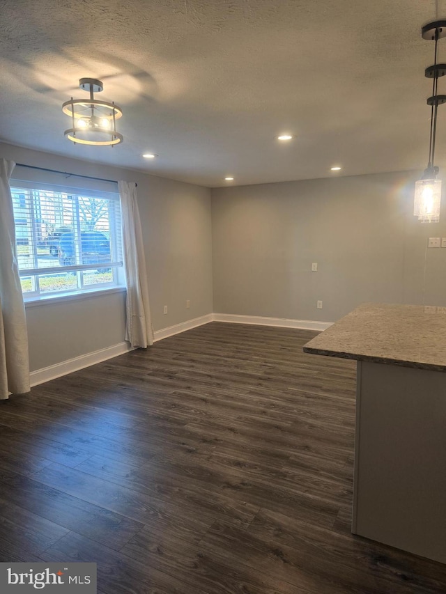 interior space featuring a textured ceiling and dark hardwood / wood-style flooring