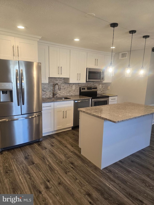 kitchen featuring white cabinetry, sink, stainless steel appliances, dark hardwood / wood-style flooring, and decorative light fixtures