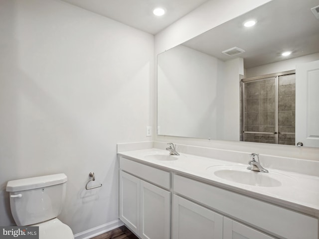 bathroom featuring vanity, toilet, and walk in shower