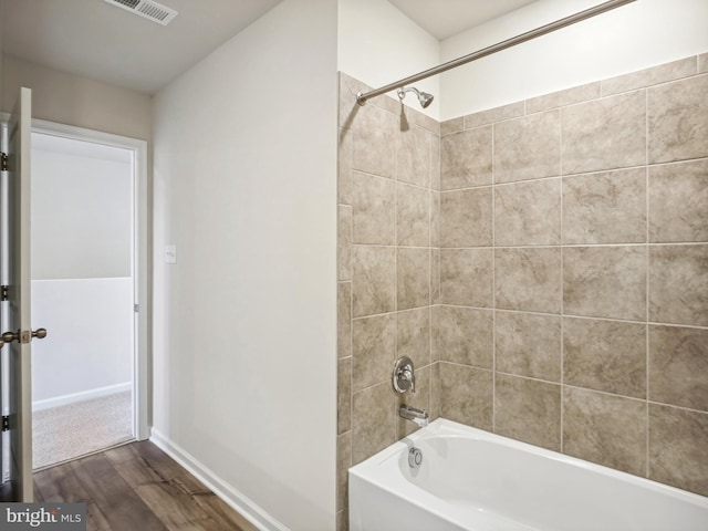 bathroom with tiled shower / bath combo and hardwood / wood-style flooring