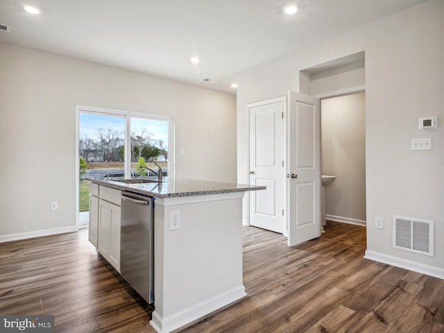 kitchen with dishwasher, a center island with sink, white cabinets, light stone counters, and dark hardwood / wood-style flooring