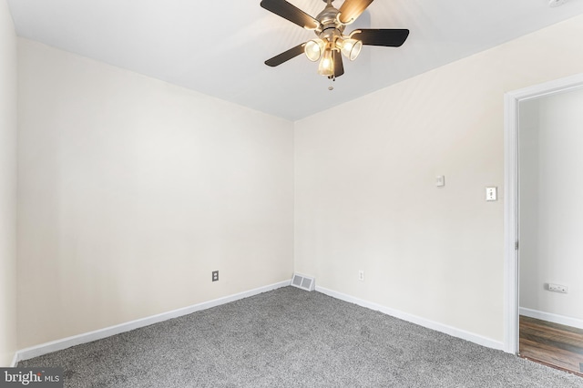 empty room featuring dark carpet and ceiling fan