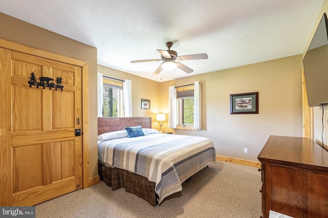 carpeted bedroom with multiple windows, ceiling fan, and a textured ceiling