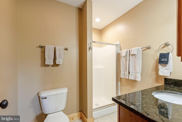 bathroom featuring a shower with door, vanity, and toilet