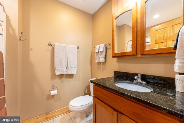 bathroom with tile patterned flooring, vanity, and toilet