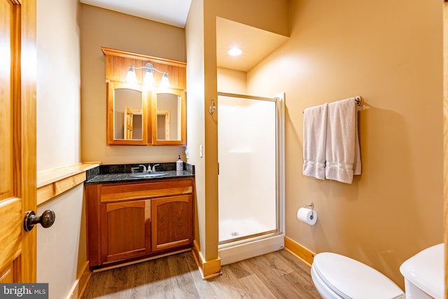 bathroom featuring hardwood / wood-style floors, vanity, toilet, and walk in shower