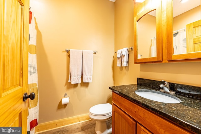 bathroom featuring wood-type flooring, vanity, and toilet