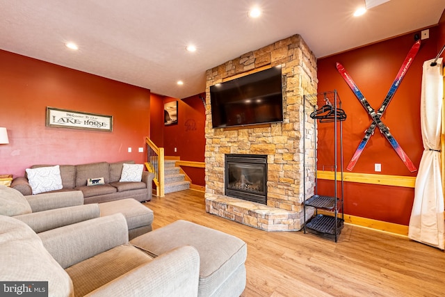 living room featuring a stone fireplace and hardwood / wood-style flooring