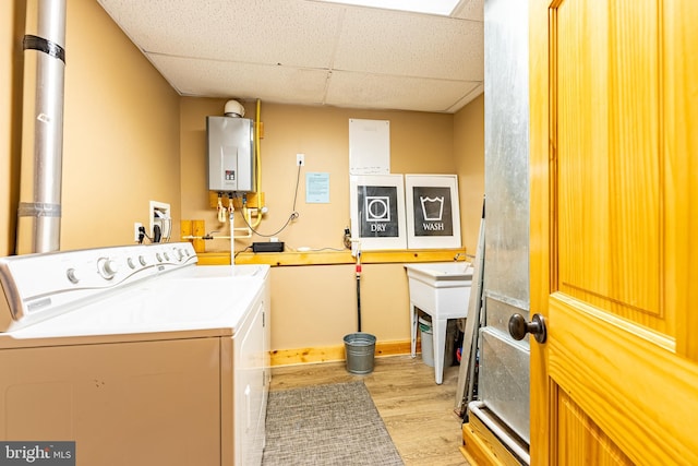 laundry room featuring light hardwood / wood-style floors, tankless water heater, and independent washer and dryer