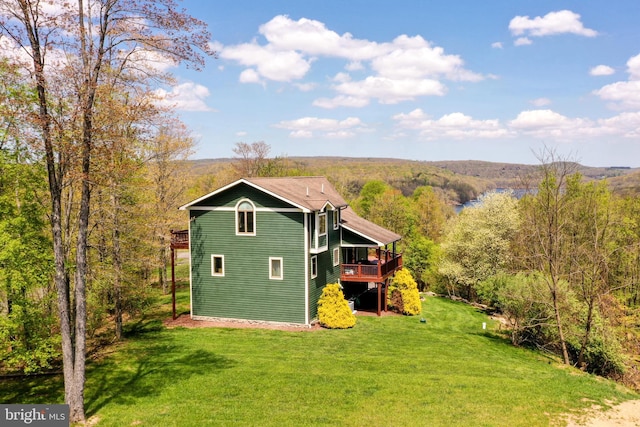 view of side of home featuring a yard and a deck