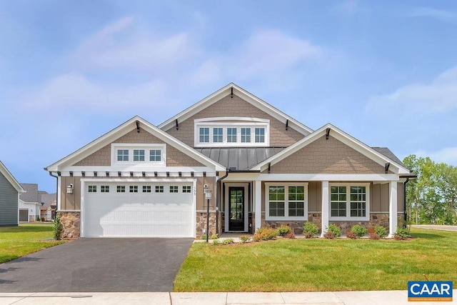 craftsman house with a front lawn and a garage