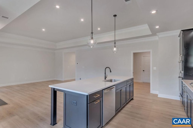 kitchen featuring a raised ceiling, sink, hanging light fixtures, stainless steel dishwasher, and an island with sink