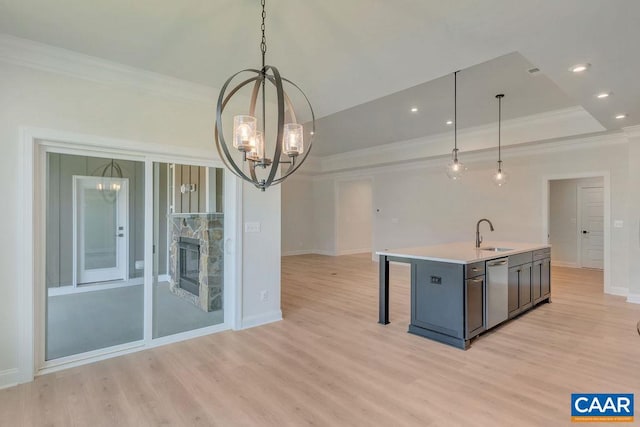 kitchen featuring a chandelier, pendant lighting, a kitchen island with sink, and sink