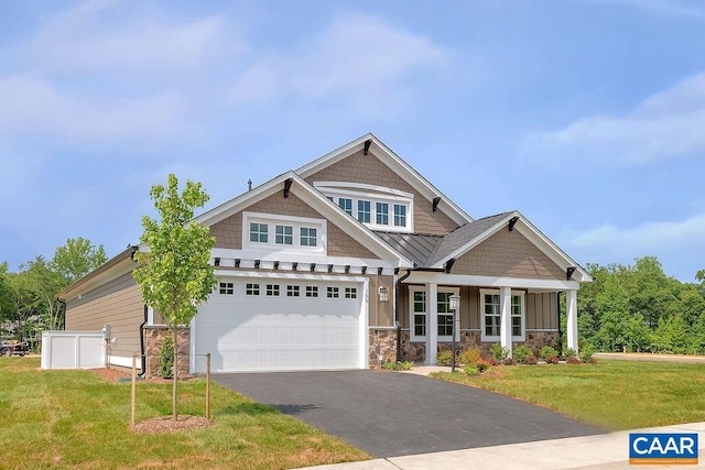 craftsman house with a garage and a front lawn