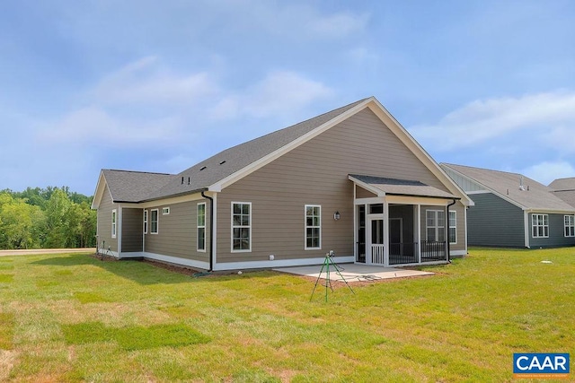 back of property featuring a yard, a patio area, and a sunroom