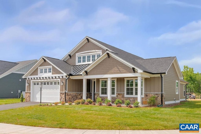 craftsman inspired home with a front lawn, a porch, and a garage