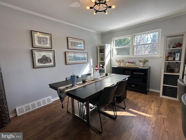 dining room with dark hardwood / wood-style flooring, crown molding, and a notable chandelier