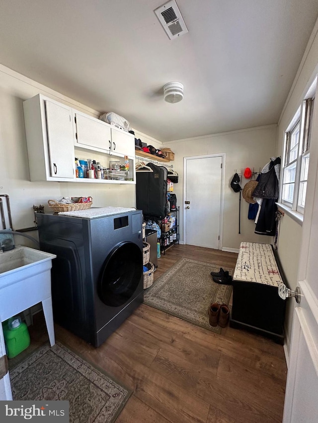 laundry area with cabinets, washer / dryer, and dark wood-type flooring