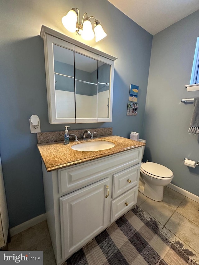 bathroom featuring toilet, vanity, and tile patterned floors