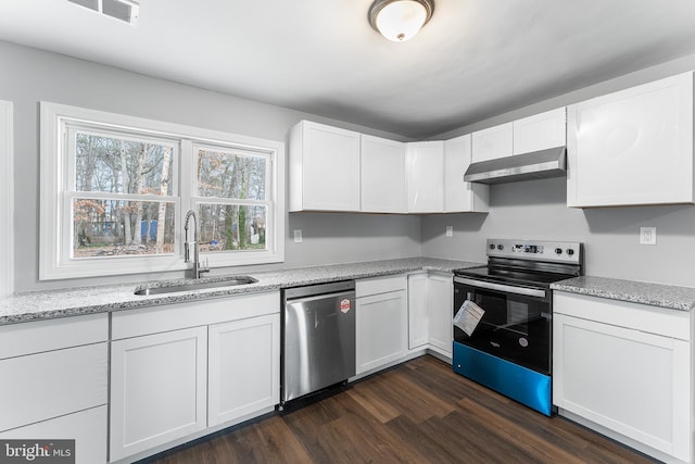 kitchen with white cabinets, sink, light stone counters, appliances with stainless steel finishes, and dark hardwood / wood-style flooring