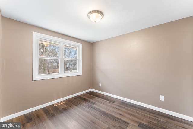 unfurnished room with dark wood-type flooring