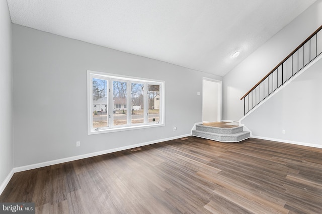 unfurnished living room with hardwood / wood-style flooring and vaulted ceiling