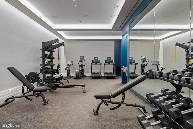 gym featuring a raised ceiling