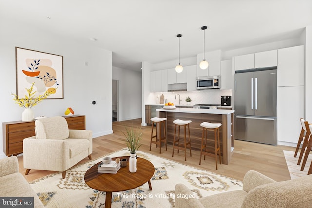 living room with sink and light wood-type flooring