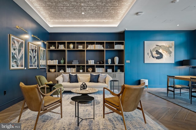 sitting room featuring a tray ceiling and parquet floors