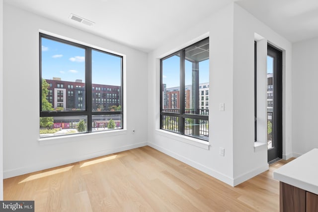 unfurnished room featuring light hardwood / wood-style flooring and plenty of natural light