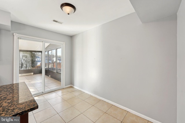 unfurnished dining area featuring baseboard heating and light tile patterned flooring