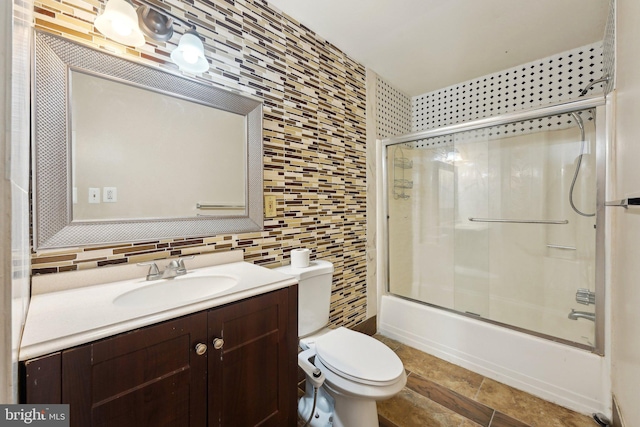 full bathroom with backsplash, toilet, vanity, and combined bath / shower with glass door