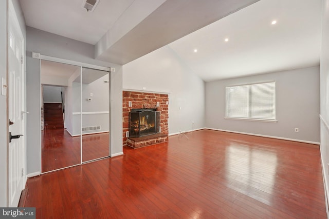 unfurnished living room with a fireplace, hardwood / wood-style flooring, and vaulted ceiling