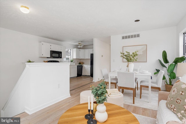 living room featuring light hardwood / wood-style floors and ceiling fan