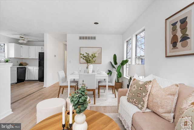 living room with ceiling fan and light hardwood / wood-style floors