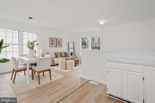 dining room with plenty of natural light and light hardwood / wood-style flooring