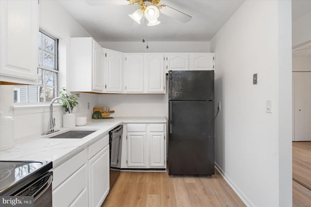 kitchen featuring black fridge, sink, ceiling fan, light wood-type flooring, and white cabinetry